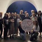 OPIRG volunteers gathered under a gazebo with a round white sign that reads "I love OPIRG"