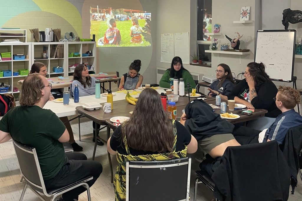 OPIRG team and community members sitting in a circle at tables in the Willow Arts Community studio.